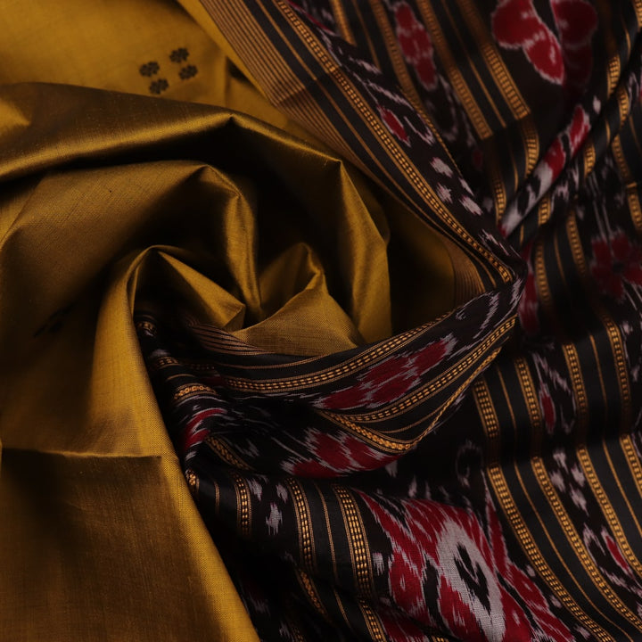 Green and black Khandua silk saree draped; showcasing its butta pattern and elegant fall.