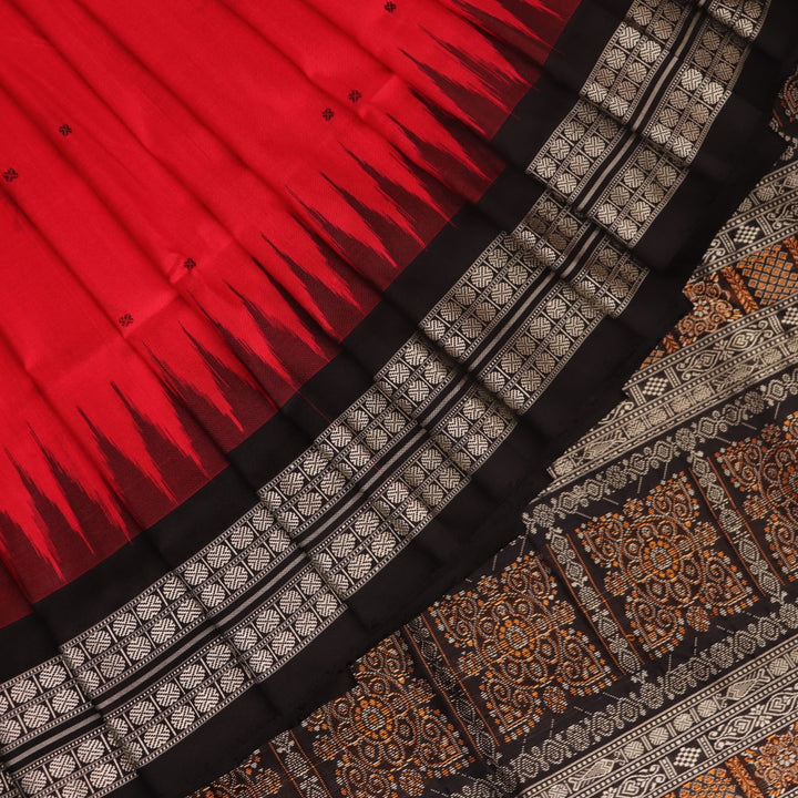 Detailed close-up of the red and black Bomkai silk saree fabric texture, featuring a butta pattern.