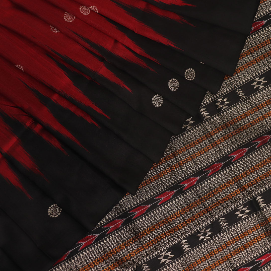 Close-up texture of handwoven Bomkai silk saree fabric: maroon and black threads forming butta pattern.