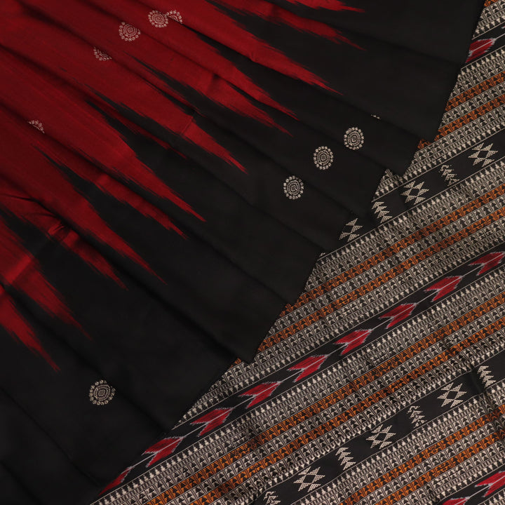 Close-up texture of handwoven Bomkai silk saree fabric: maroon and black threads forming butta pattern.