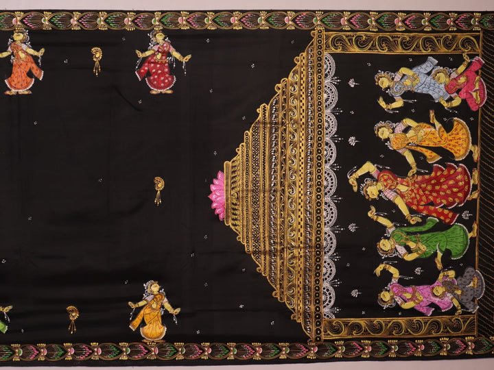 Close-up of black silk Patachitra saree fabric texture showing hand-painted details.