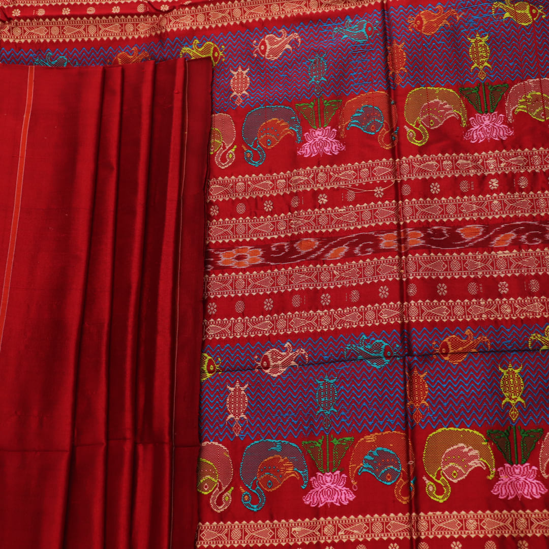 Close-up of maroon plain Sambalpuri silk saree fabric texture.