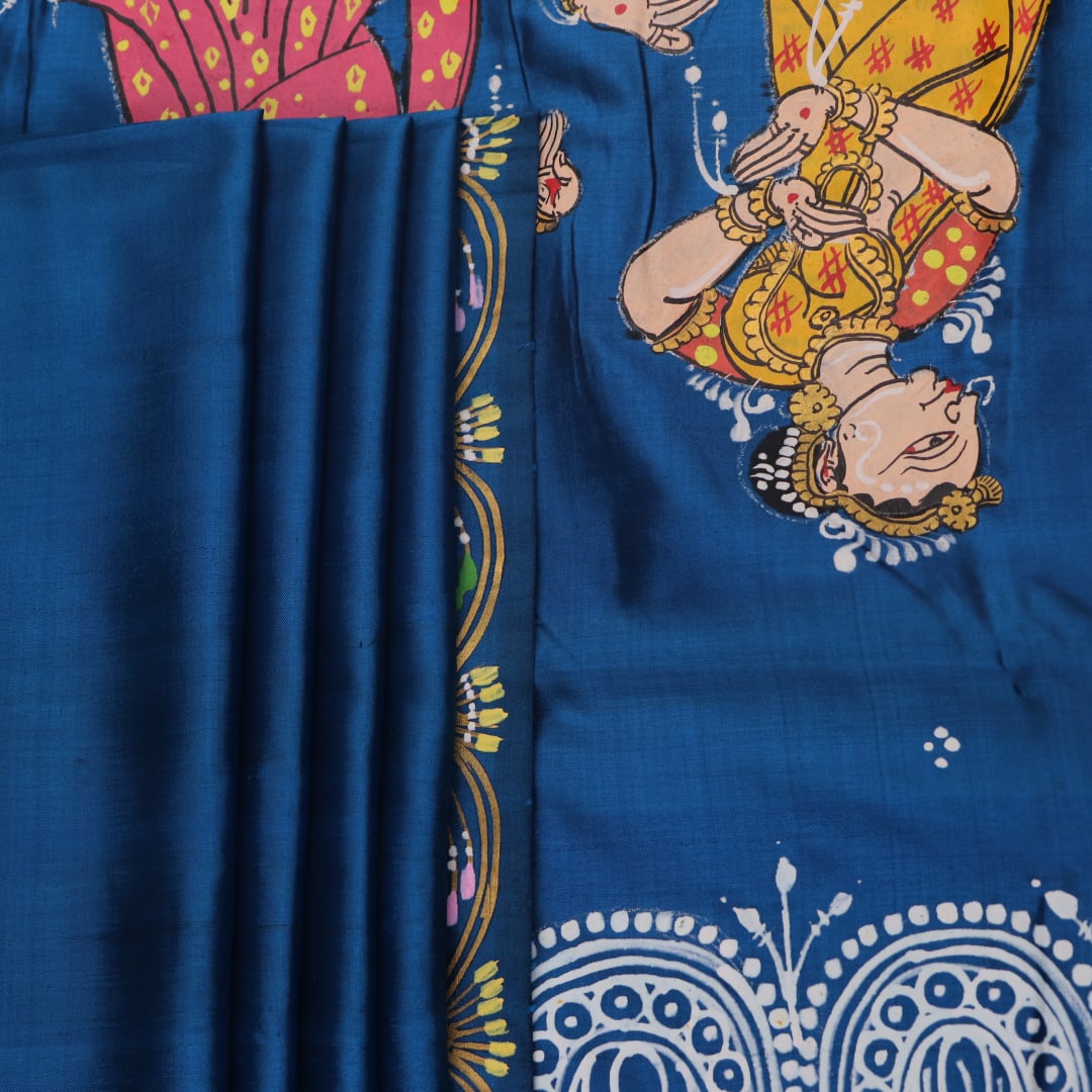 Close-up of handloom blue silk Patachitra saree fabric, showcasing the fine texture and hand-painted details.