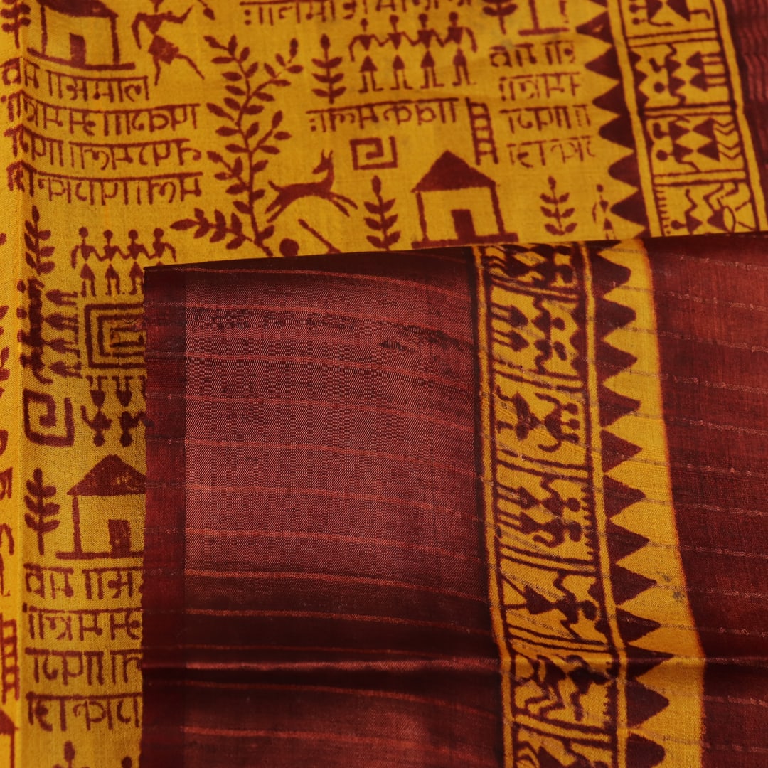 Close-up showing the textured weave of a yellow and brown printed Tussar silk saree.