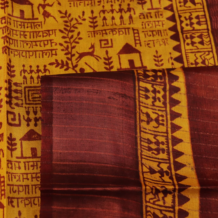 Close-up showing the textured weave of a yellow and brown printed Tussar silk saree.