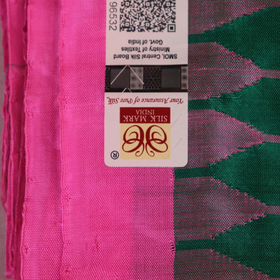 Close-up of plain green and pink Sambalpuri silk saree fabric texture.