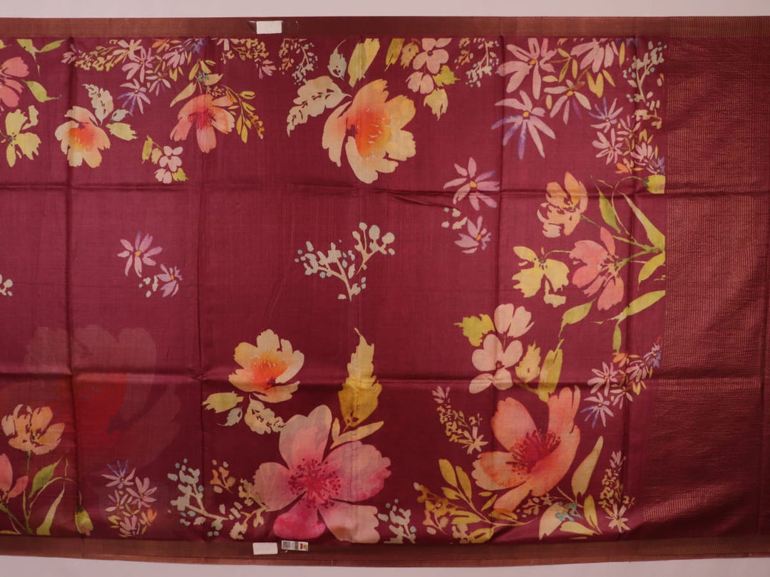 Close-up of maroon Tussar silk saree fabric, emphasizing its distinct texture and printed pattern.