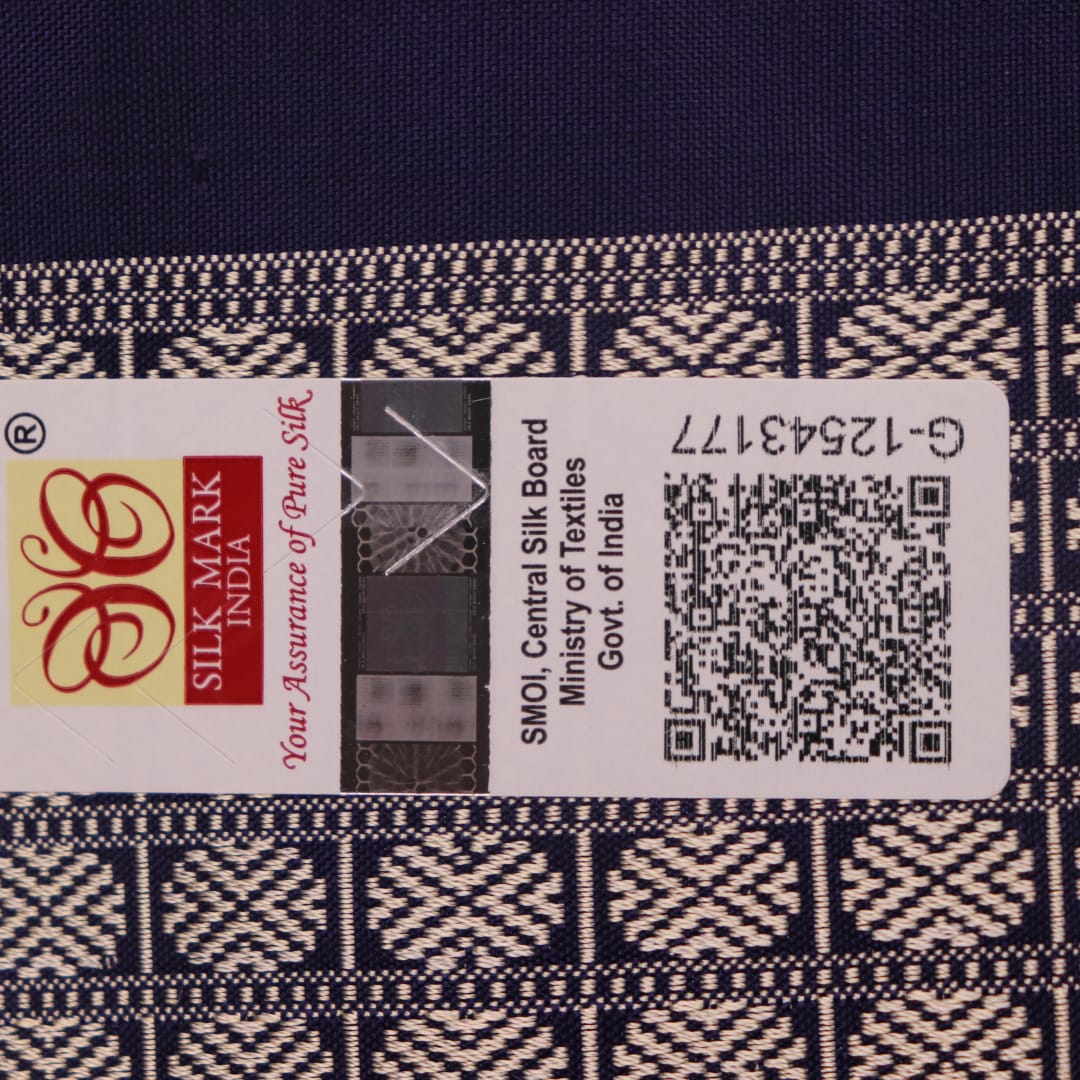 Close-up fabric texture of a blue Bomkai silk saree, revealing intricate butta pattern weave.