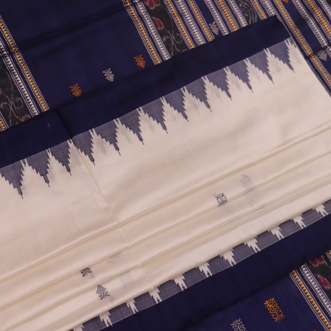 Close-up of white and blue Sambalpuri Silk Saree fabric texture, highlighting butta pattern.