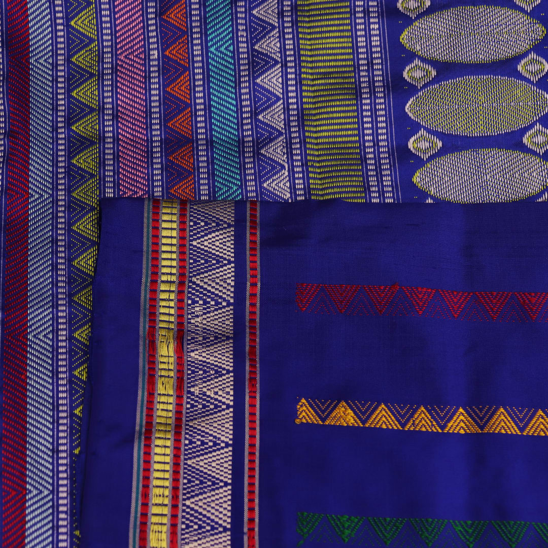 Close-up of green and blue Dongria silk saree fabric texture with butta pattern.