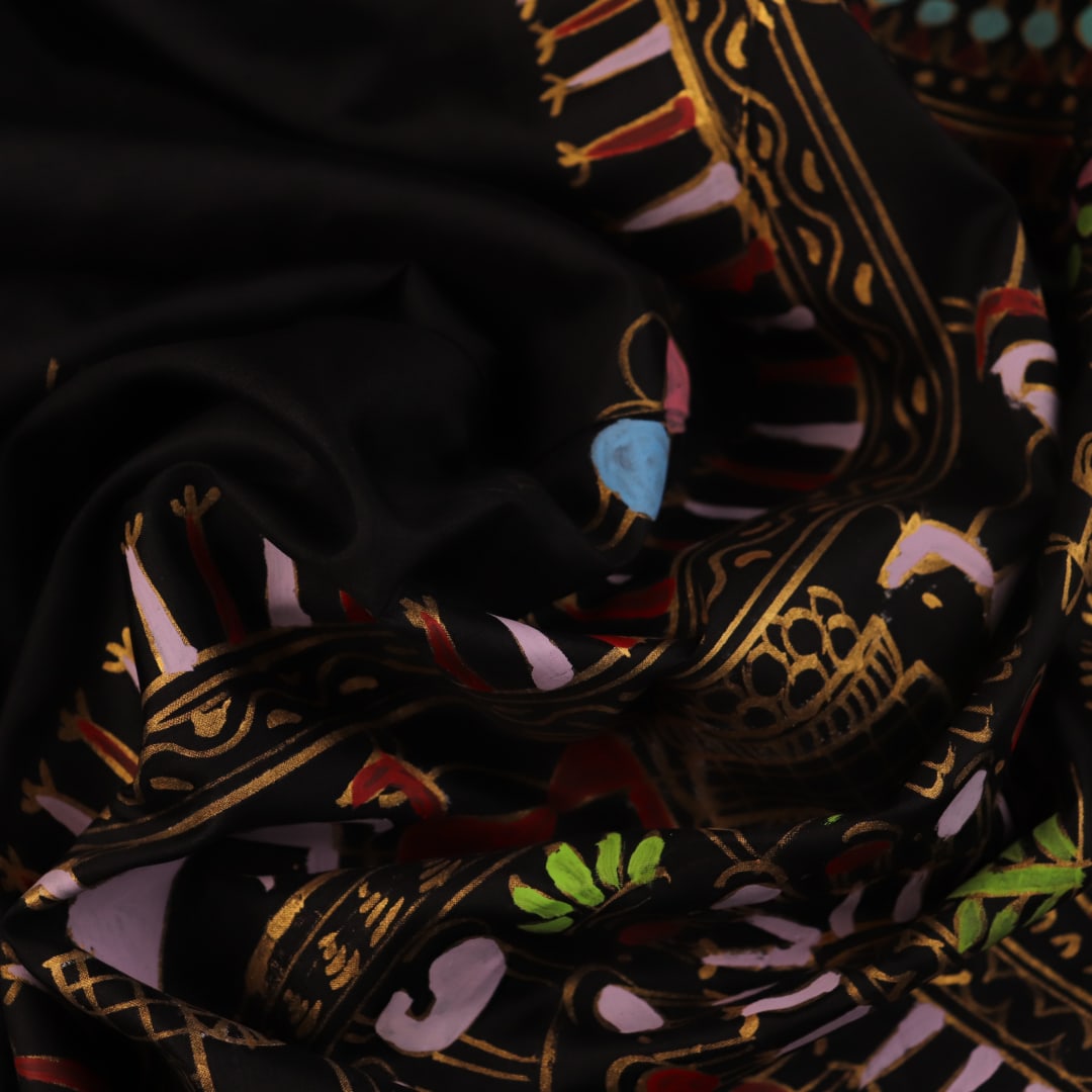 Close-up of the black silk Patachitra saree, showcasing the hand-painted fabric texture.