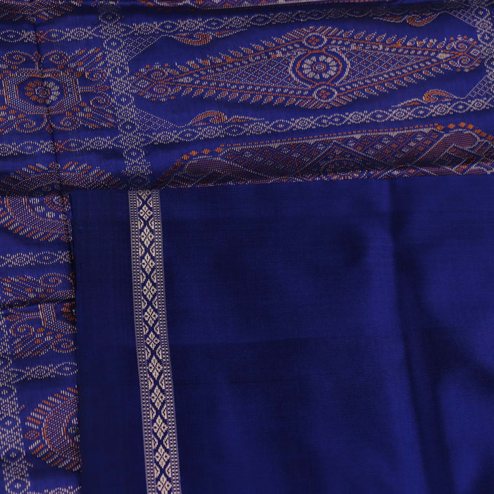 Textured close-up of yellow Bomkai silk saree fabric with blue butta pattern.