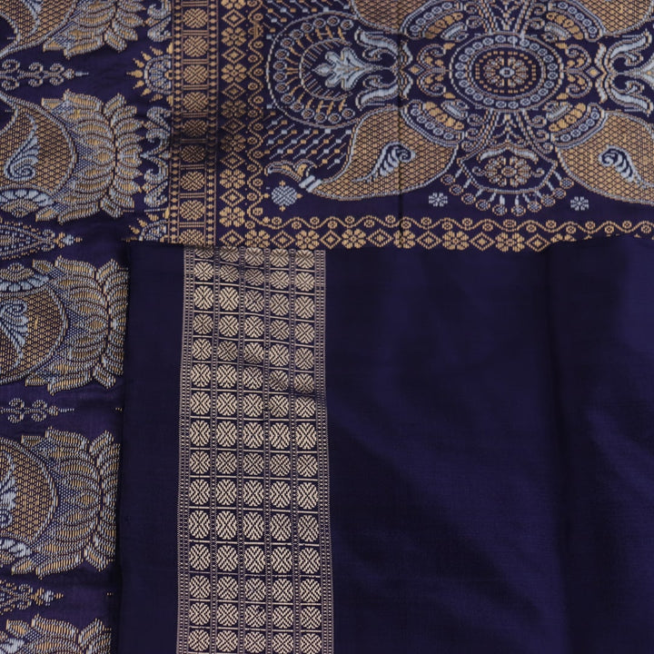 Close-up fabric texture of a blue Bomkai silk saree, revealing intricate butta pattern weave.