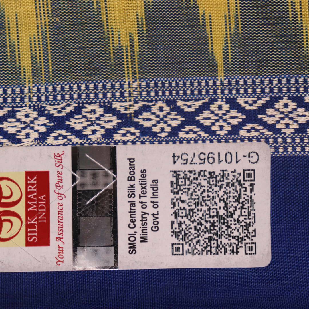 Textured close-up of yellow Bomkai silk saree fabric with blue butta pattern.