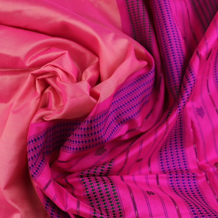Close-up of plain peach and pink Sambalpuri silk saree fabric texture.