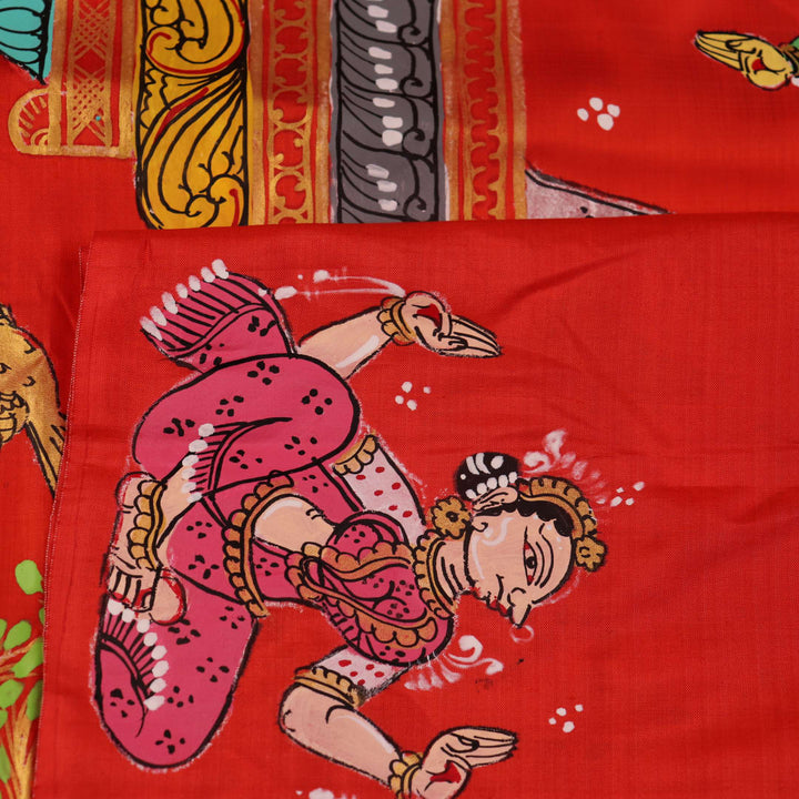 Close-up of red Patachitra silk saree fabric showing hand-painted texture.