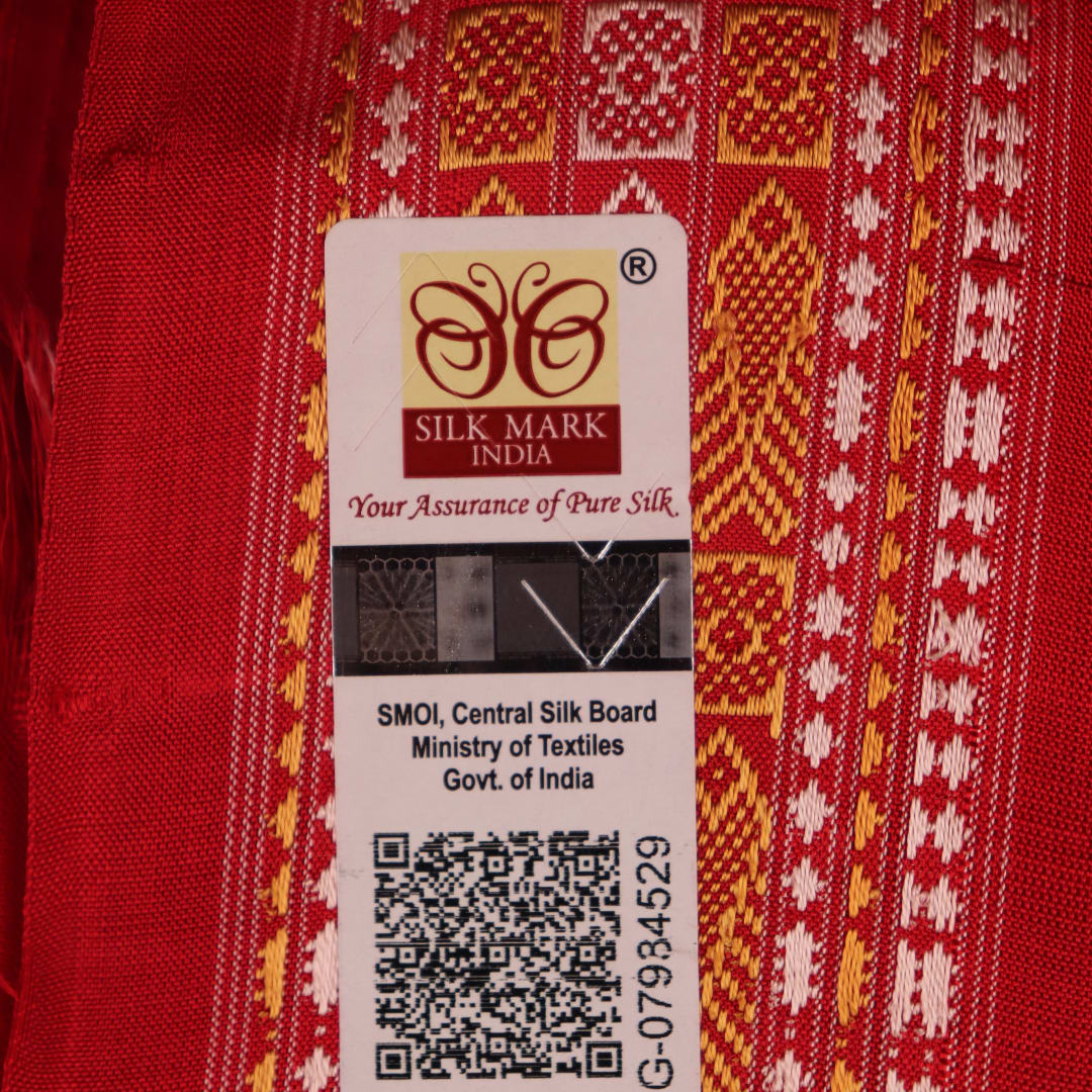 Close-up of the distinct handwoven texture of a red Sambalpuri silk saree with Butta pattern.