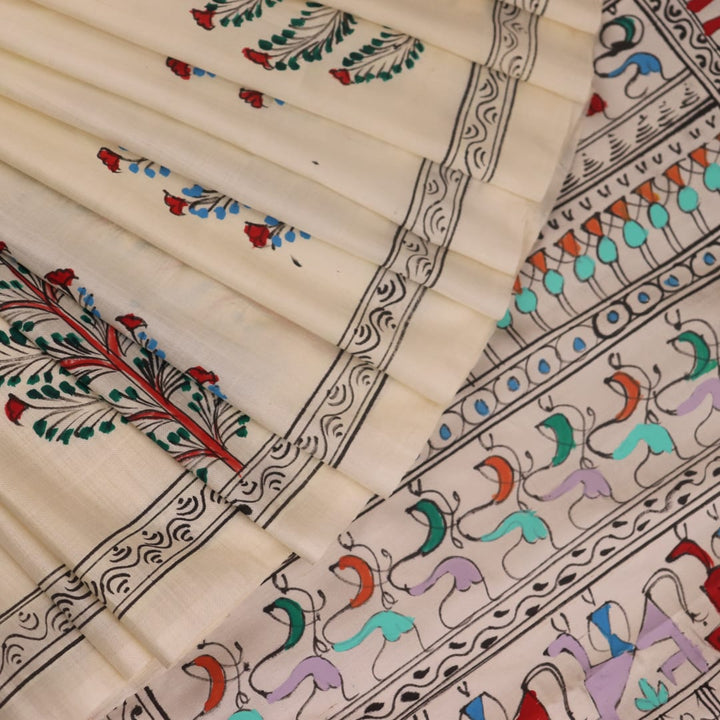 Close-up of the white silk saree fabric texture, showcasing the handloom weave and painted Patachitra details.