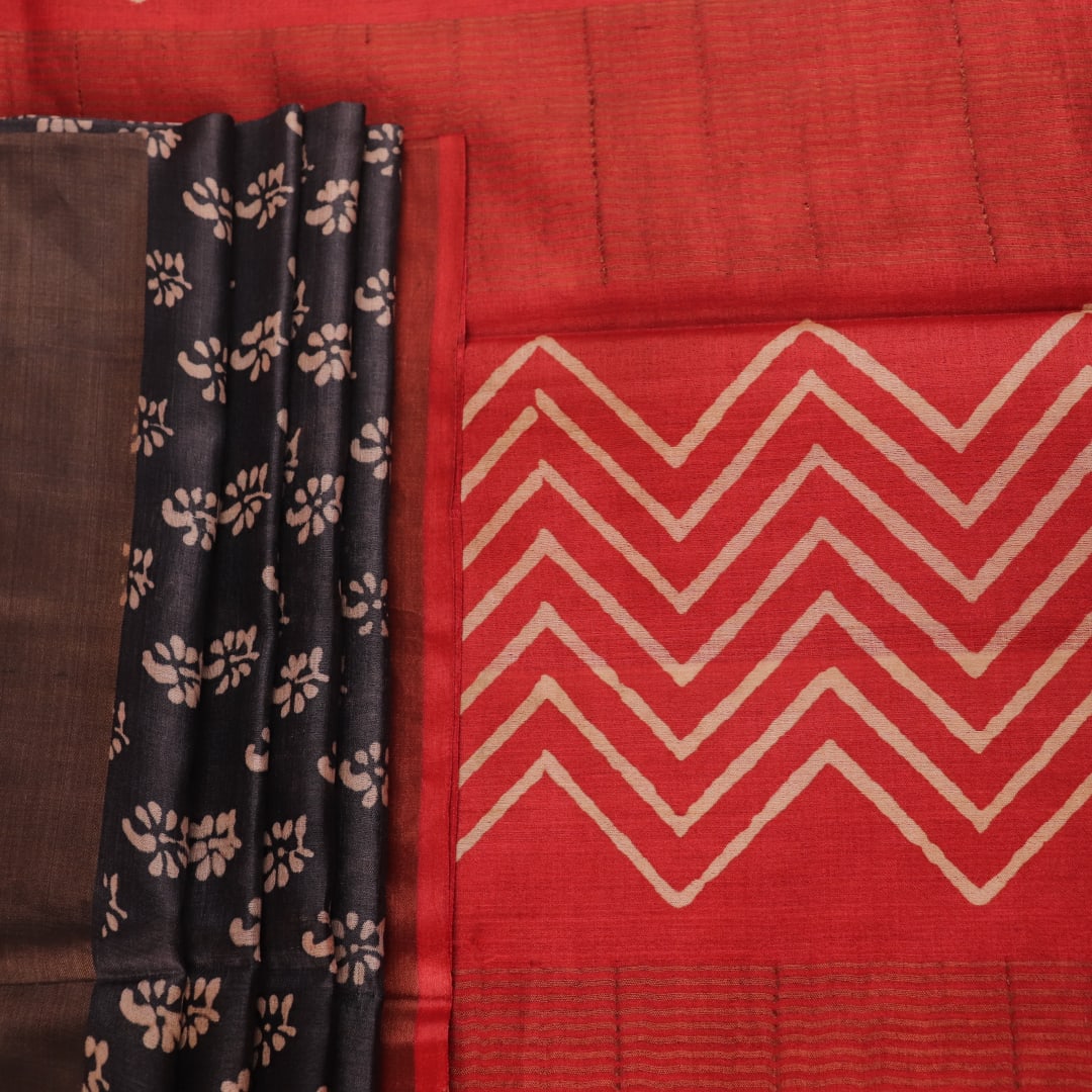 Close-up of the subtle slub and print on a handloom grey and rust Tussar silk saree fabric.
