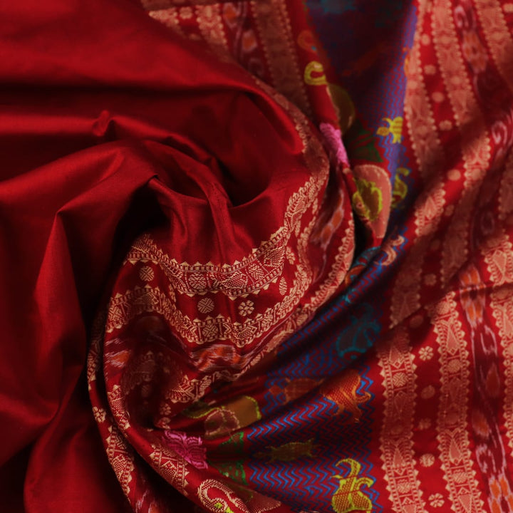 Close-up of maroon plain Sambalpuri silk saree fabric texture.