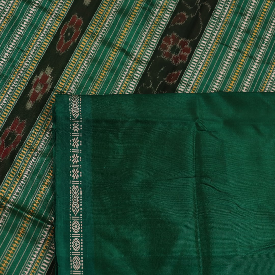 Close-up of the plain woven silk texture of a pink and green Sambalpuri saree.