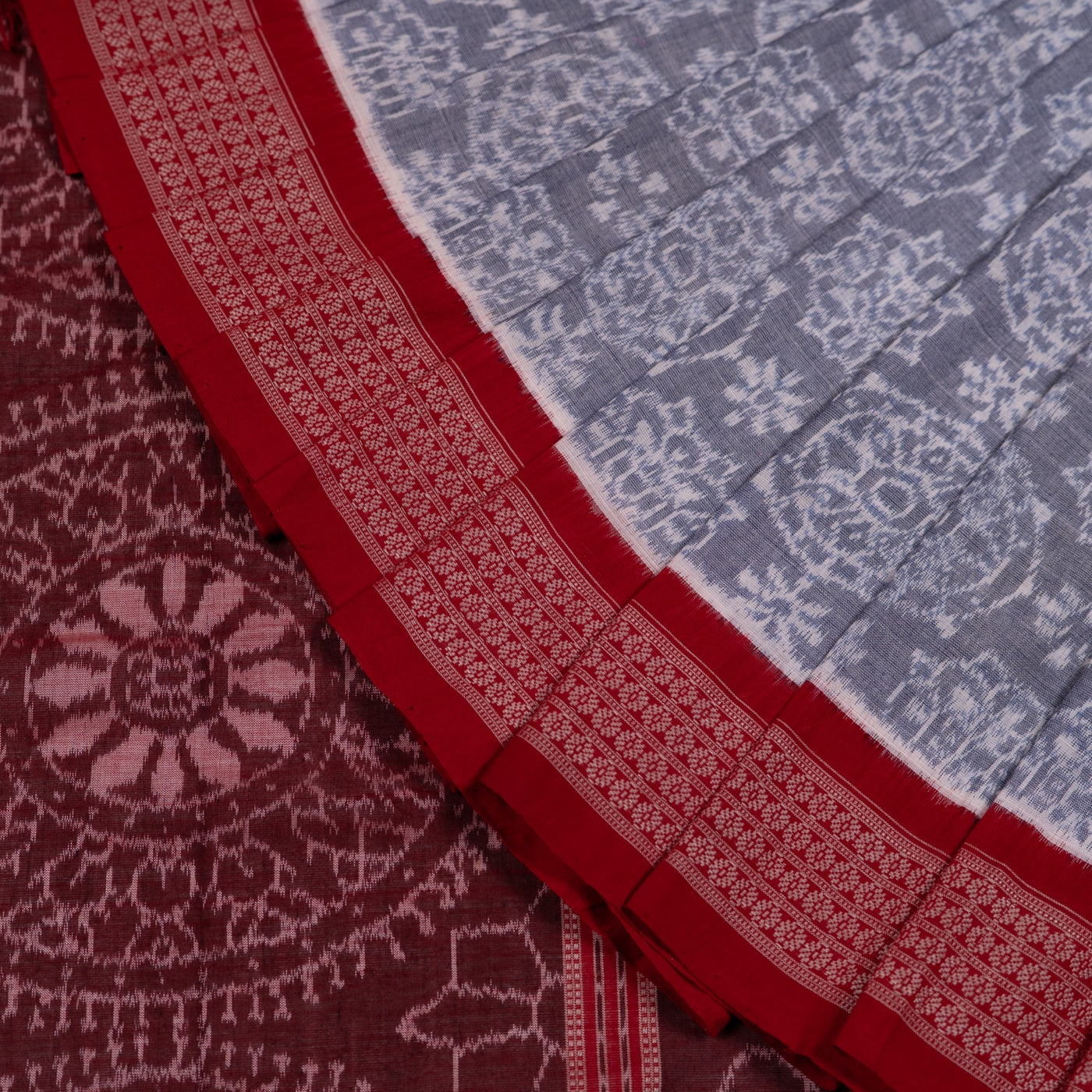 Folded presentation of the Grey and Red Sambalpuri cotton saree.