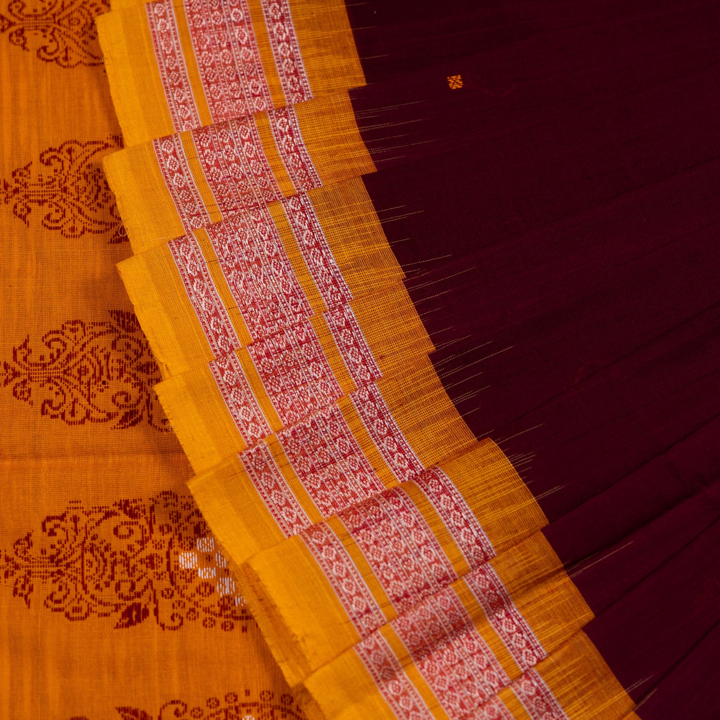 Folded presentation of the Maroon and Yellow Bomkai cotton saree.