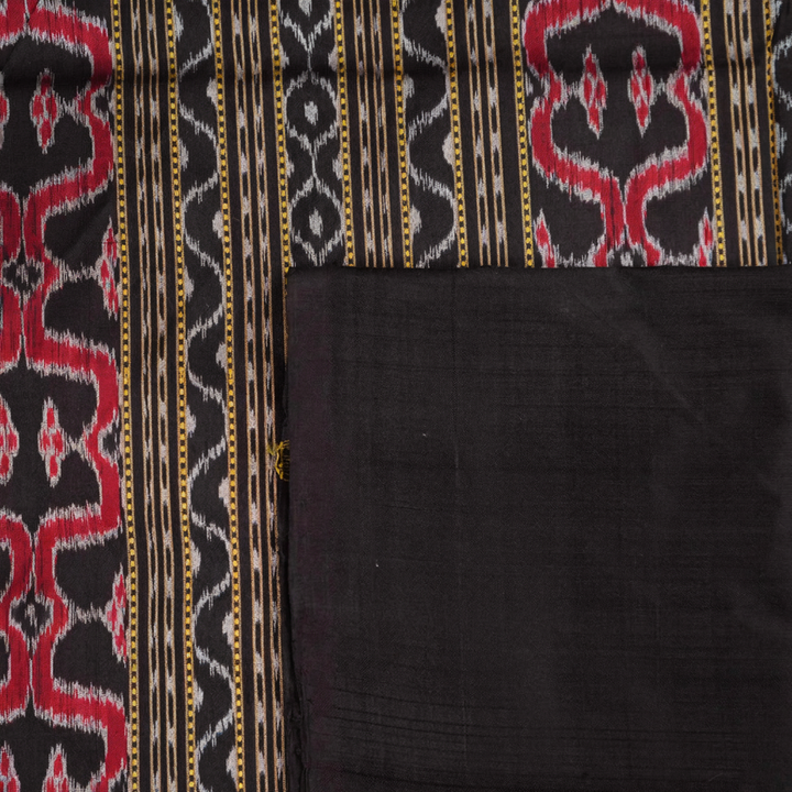 Close-up of the luxurious, handloom silk texture of the red Sambalpuri saree, showing the weave.