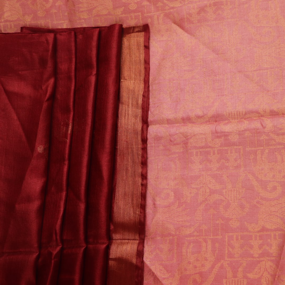 Close-up of intricate butta pattern woven on Tussar silk fabric in a maroon hue