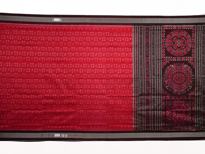 Ultra close-up of the red Sambalpuri silk saree fabric, revealing its luxurious texture and handloom weave.