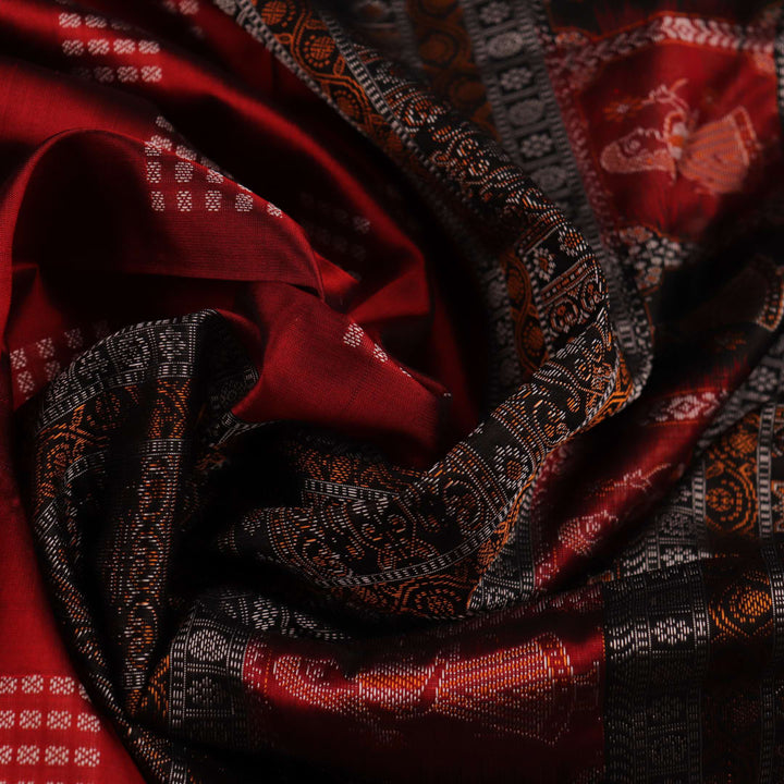 Close-up of maroon silk fabric with delicate butta patterns in black.