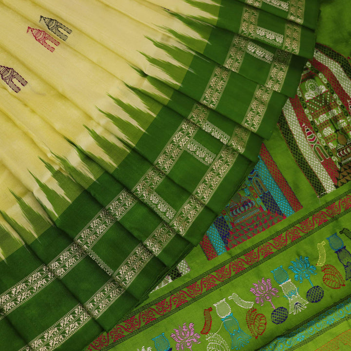 Close-up of cream and green Bomkai Silk Saree fabric texture with butta pattern.