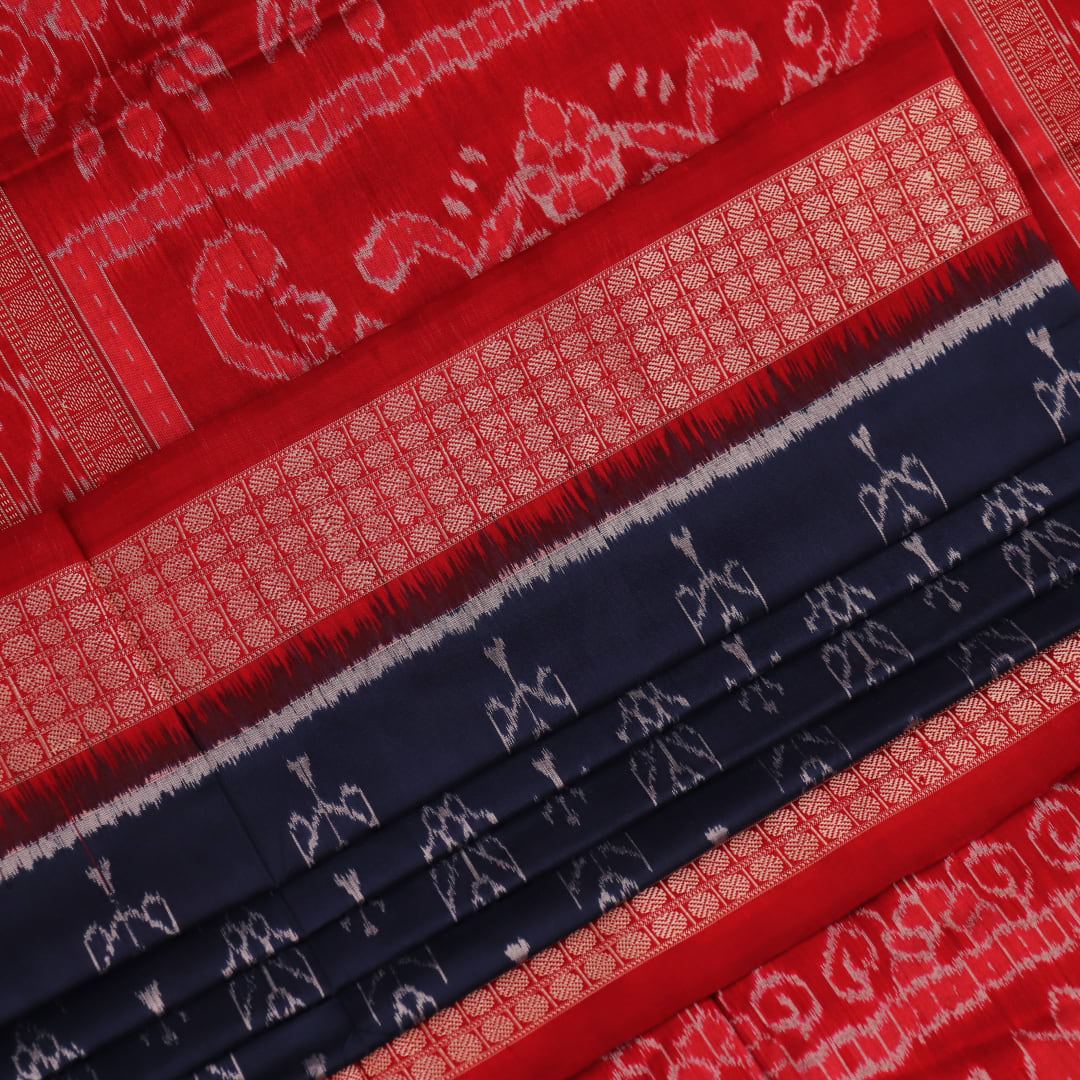 Close-up view of the blue silk Sambalpuri saree's fabric texture showcasing intricate motifs in red