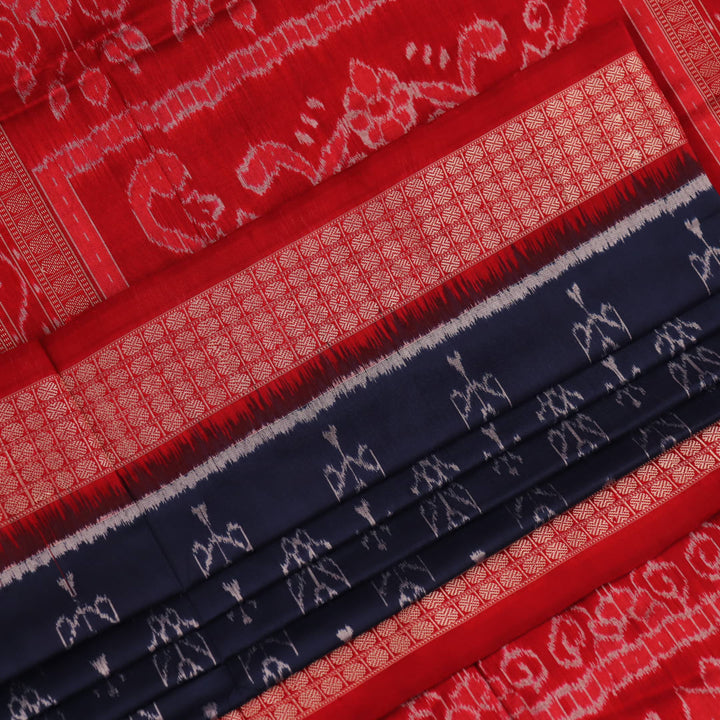 Close-up view of the blue silk Sambalpuri saree's fabric texture showcasing intricate motifs in red