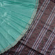 Ultra close-up of the luxurious green Sambalpuri handloom silk weave, highlighting its smooth texture.