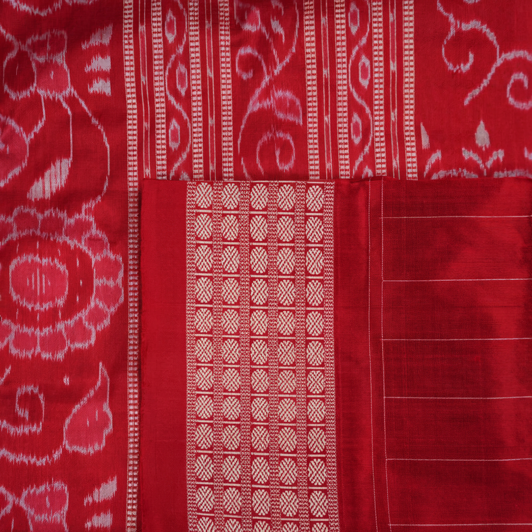 Close-up of the maroon Sambalpuri silk saree fabric, highlighting its luxurious texture and intricate weave.