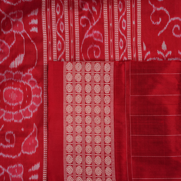Close-up of the maroon Sambalpuri silk saree fabric, highlighting its luxurious texture and intricate weave.