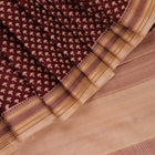 Close-up of maroon Tussar silk saree fabric, showing natural slub texture and printed pattern.