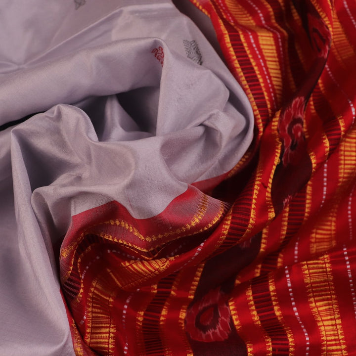 Close-up of grey and red Sambalpuri Silk saree fabric texture, highlighting butta pattern weave.