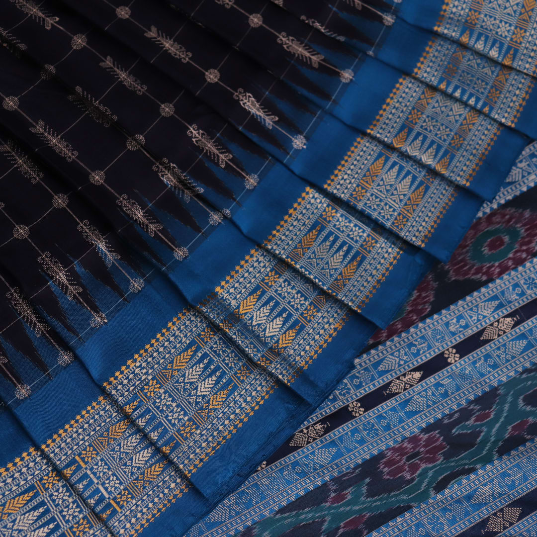 Close-up of handwoven Sambalpuri black silk saree fabric with intricate butta pattern