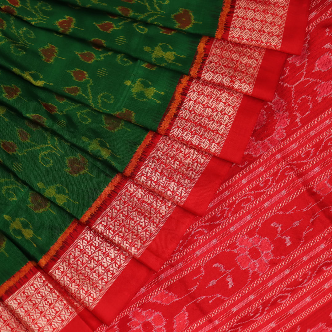 Close-up of green and orange silk Sambalpuri saree fabric with intricate motif patterns