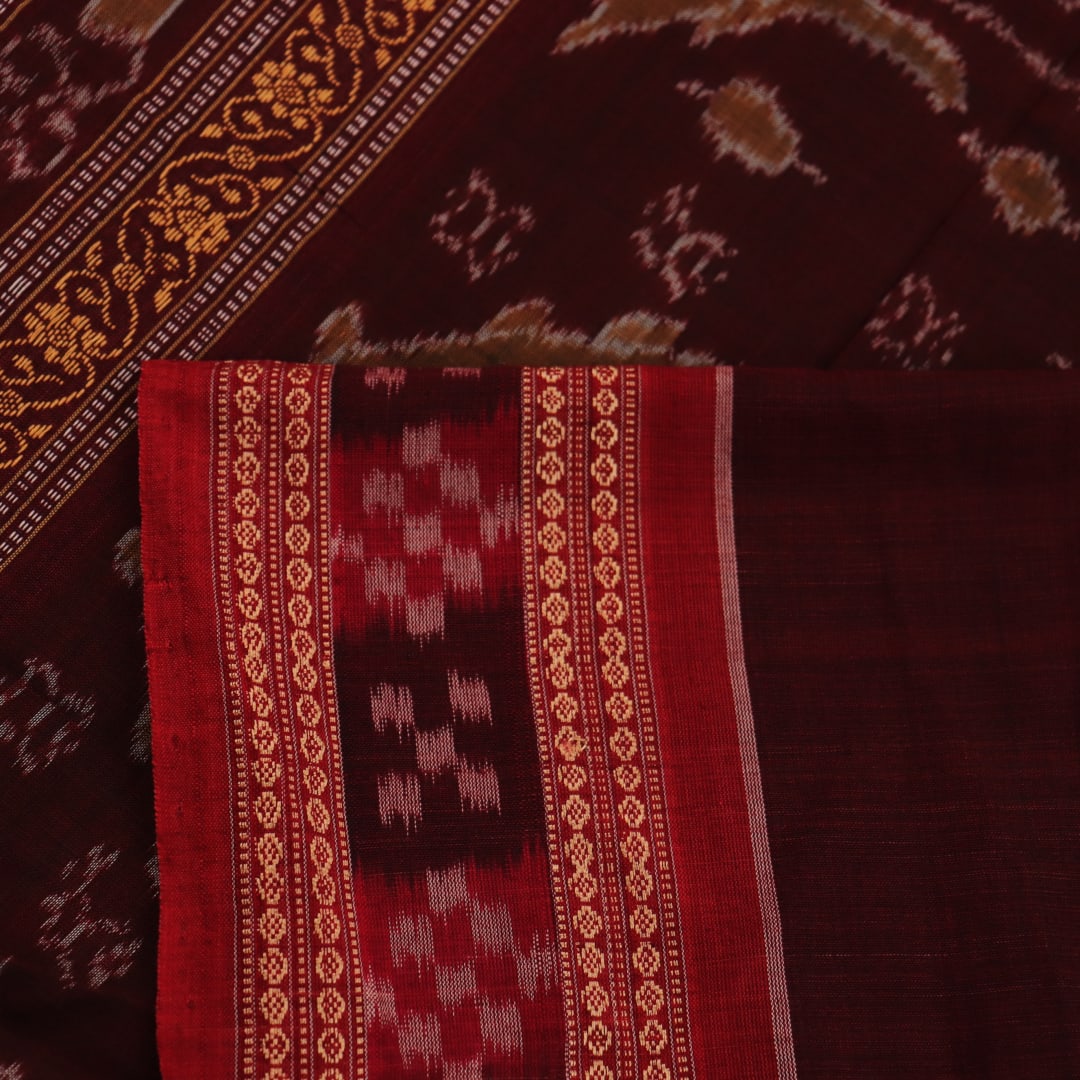 Full view of a green and rust cotton Bomkai saree with traditional butta patterns.