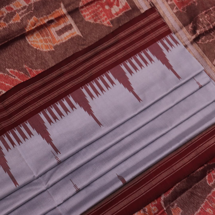 Close-up of grey and maroon Sambalpuri Silk Saree's butta pattern fabric texture.