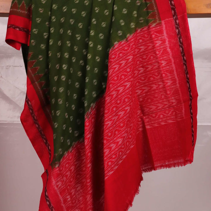 A woman wearing a green and red cotton Sambalpuri dupatta with motifs draped over her shoulder