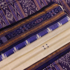 Woman elegantly draped in a white and blue Khandua silk saree with butta pattern.