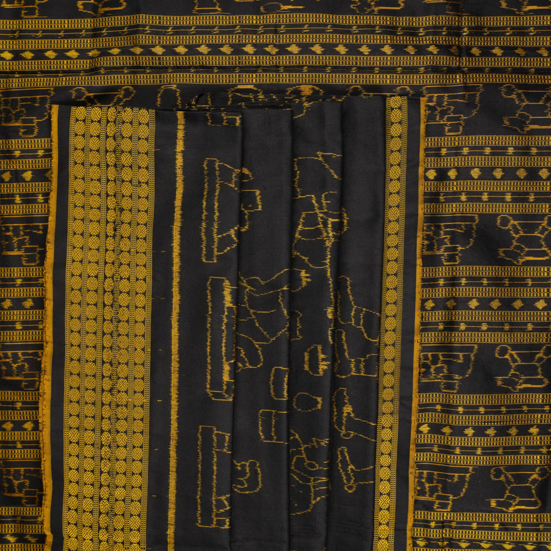 Close-up of the black Sambalpuri silk saree fabric, revealing its rich texture and the intricate weave of the motifs.