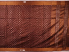Close-up of the brown Tussar silk saree fabric, highlighting its natural slub texture and printed pattern.