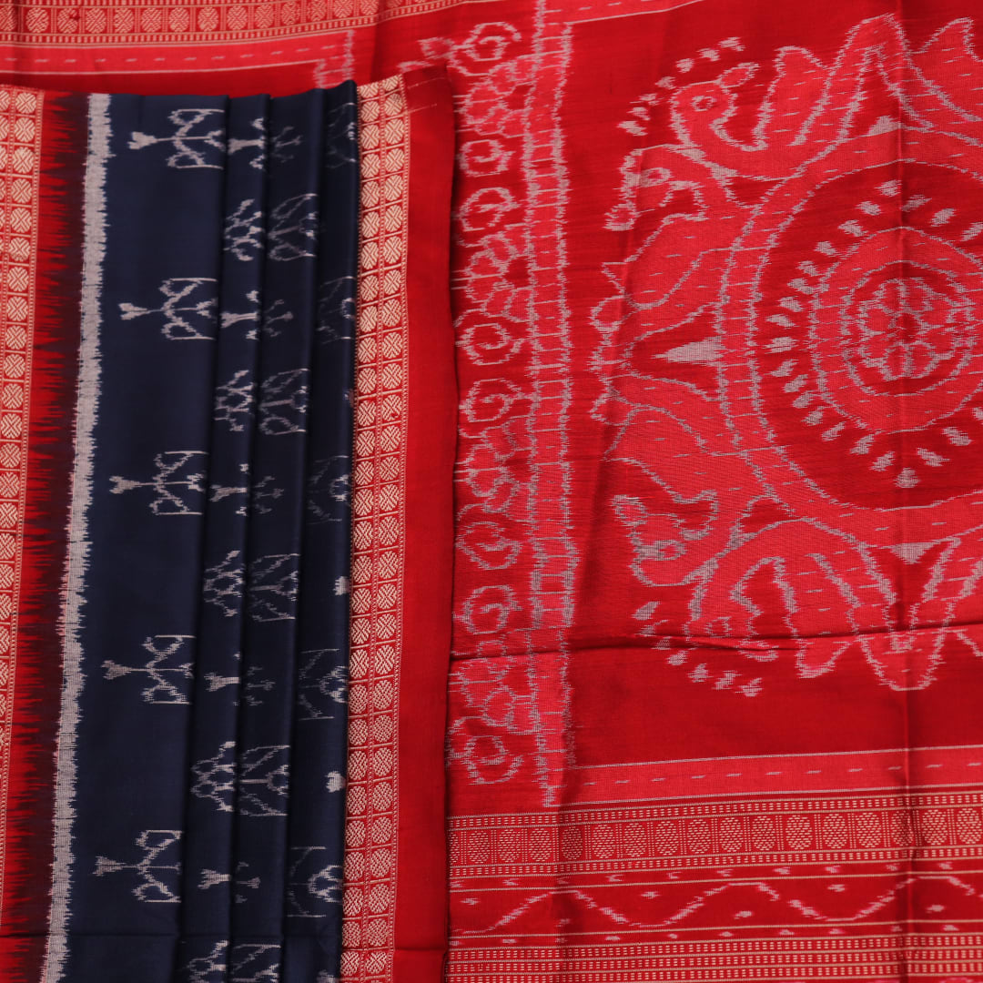 Close-up view of the blue silk Sambalpuri saree's fabric texture showcasing intricate motifs in red