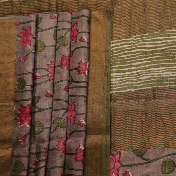 Close-up view of grey Tussar silk saree with intricate motifs on its textured fabric