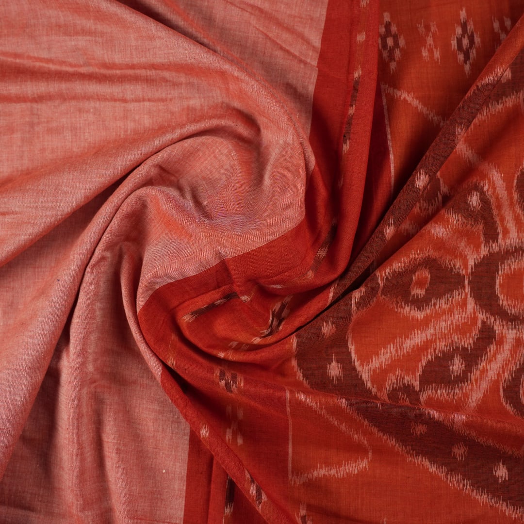 Professional styling view of a rust Sambalpuri cotton saree draped on a model for an elegant ethnic look.